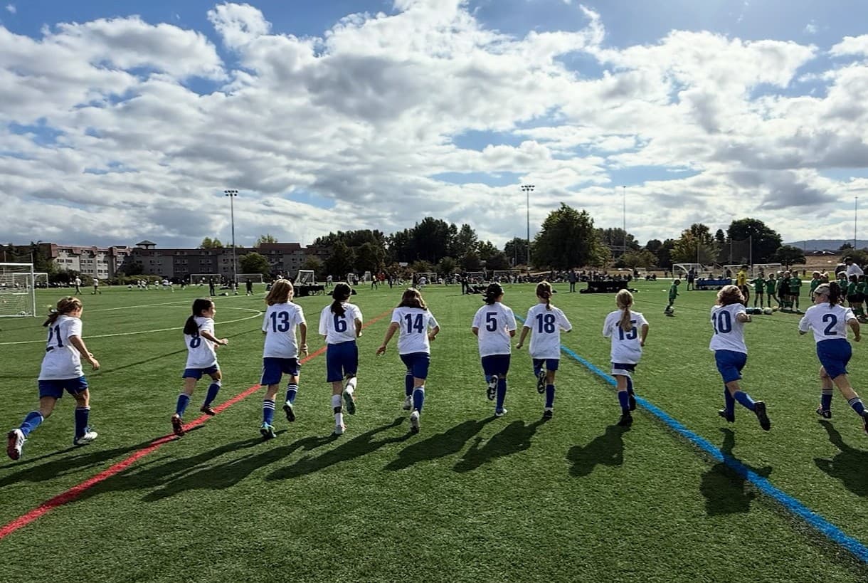 Youth soccer players running onto a field